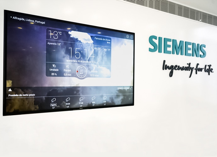 Foto von der TEOS-Installation von Siemens Portugal, das ein an die Wand montiertes BRAVIA Professional Display zeigt, das für Digital Signage verwendet wird. Das Siemens-Logo wird an der Wand angezeigt.