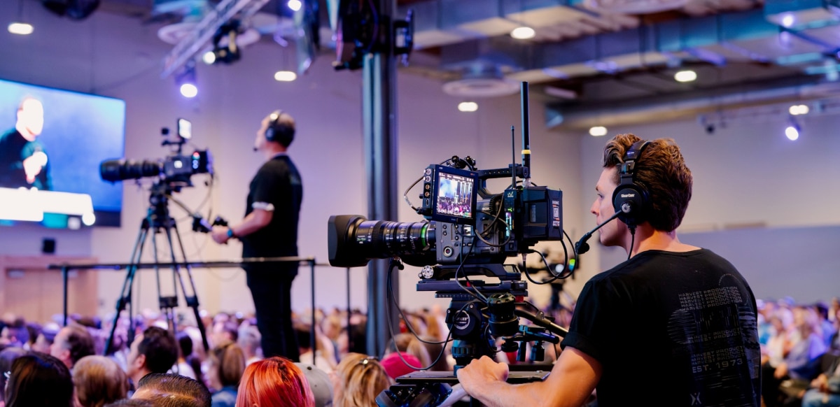 Camera operators with Sony cameras in the audience for a faith-based event.