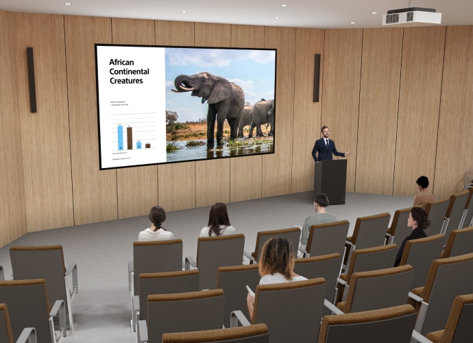 People sitting auditorium with a projector screening a presentation.