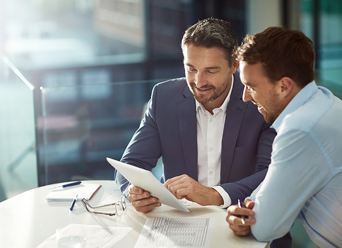 Two guys are discussing business at the table.