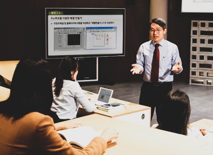 Lecturer at Cyber University Korea gives presentation in front of screen