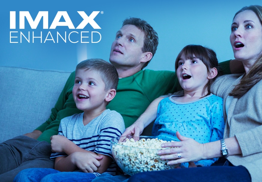 Family enjoying home cinema experience with the VPL-XW7000ES with IMAX Enhanced logo.