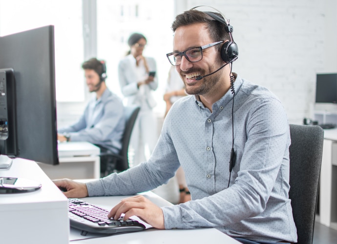 Man with glasses working in office with headphones on