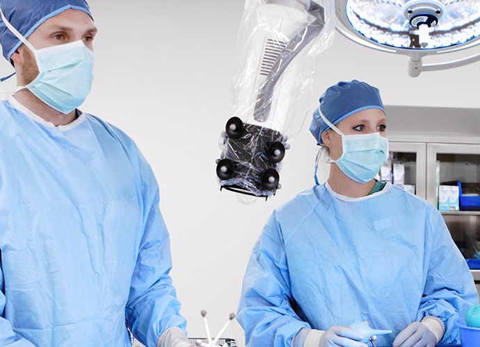 Two surgeons conducting heads-up surgery using a robotic digital microscope