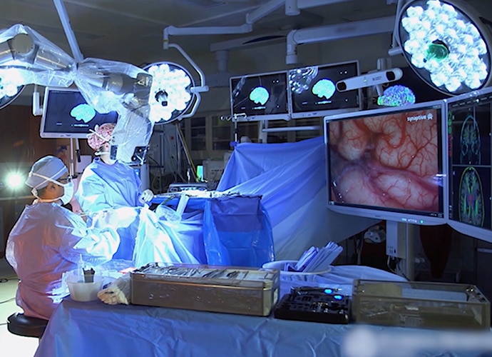 Two Sony LMD-X550MD 55 inch 4K monitors being used as a heads-up display for a robotic digital microscope during surgery