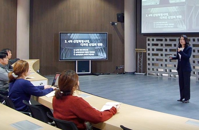 A lecturer presents before a hall full of students at the Cyber University of Korea