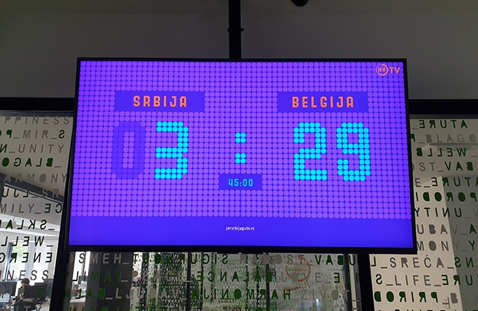 BRAVIA display showing time on the screen with letter behind on the wall