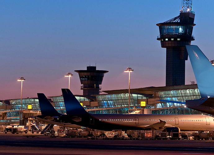 Illustrative image showing an airport at night with plnes parked in the termac