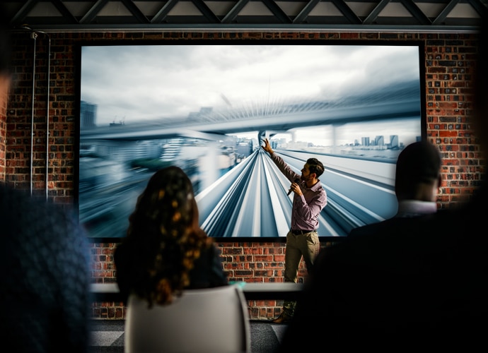 Man pointing at a projection image, showing a fast-moving image.