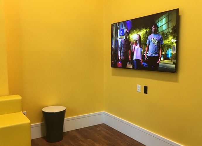 Image showing the interior of another breakout room, showing a UCF-themed image on the BRAVIA monitor.