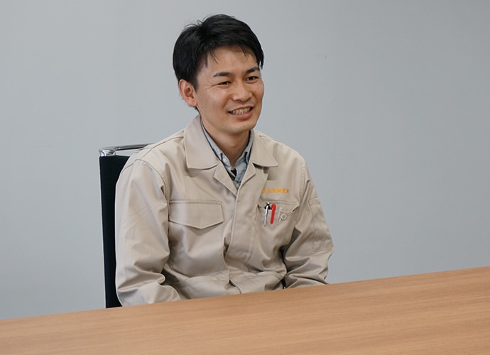 Nara Man smiling at desk