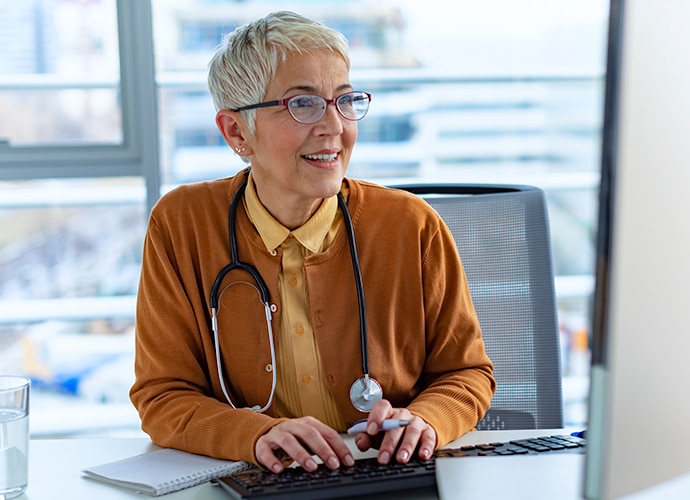 A senior doctor at her desk