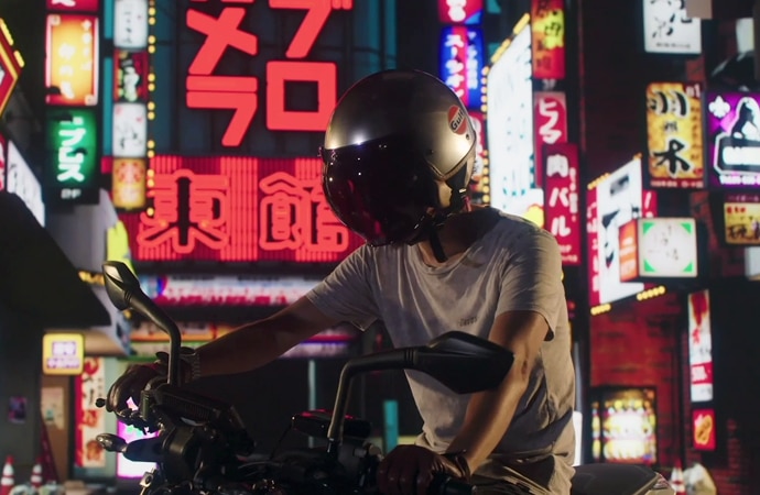 A motorcyclist on his bike in front of a Tokyo streetscene, rendered using Virtual Production