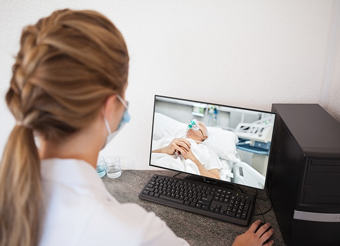 doctor stares at screen displaying critical patient in the icu