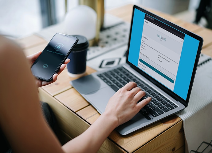 Person mit einem Laptop, auf dem die Anmeldung bei NUCLeUS LIVE zu sehen ist