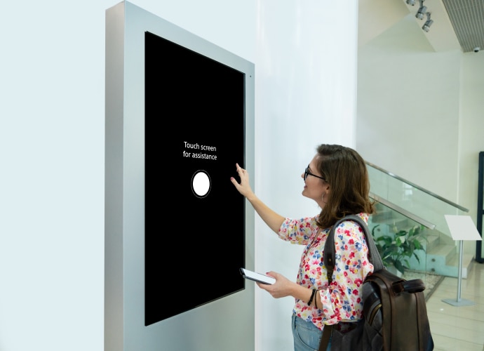 Customer checks professional display with black screen and message “touch screen for assistance”