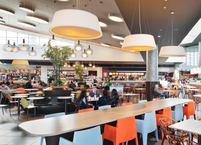 Food court with on-ceiling displays showing menu boards