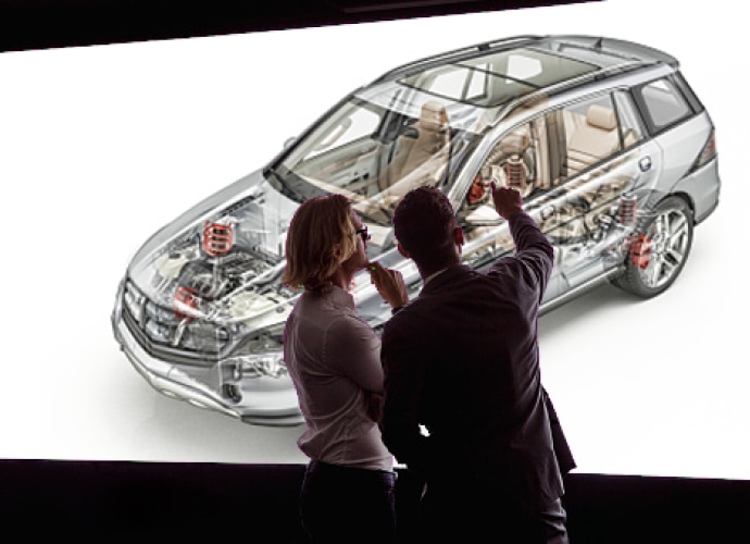 Two people looking at a car on a professional display