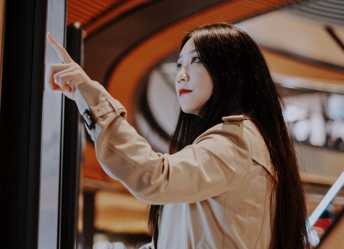 Woman touches screen in shopping center