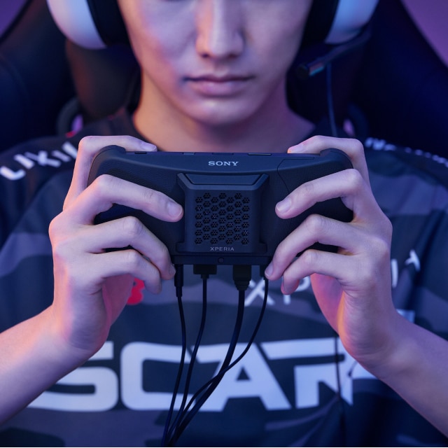 A person holding a Sony gaming controller