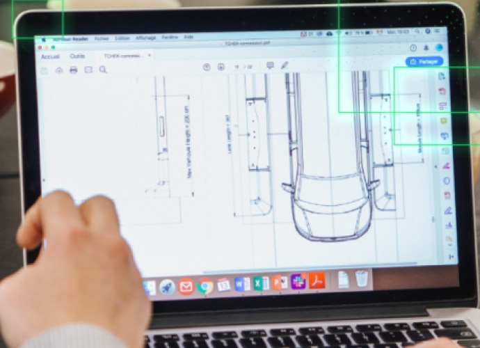 Hands typing on a laptop keyboard with a car diagram on the screen