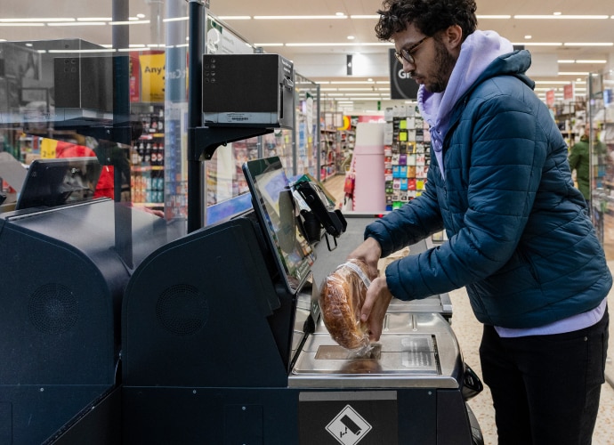 A woman scanning a product in a self-checkout counter