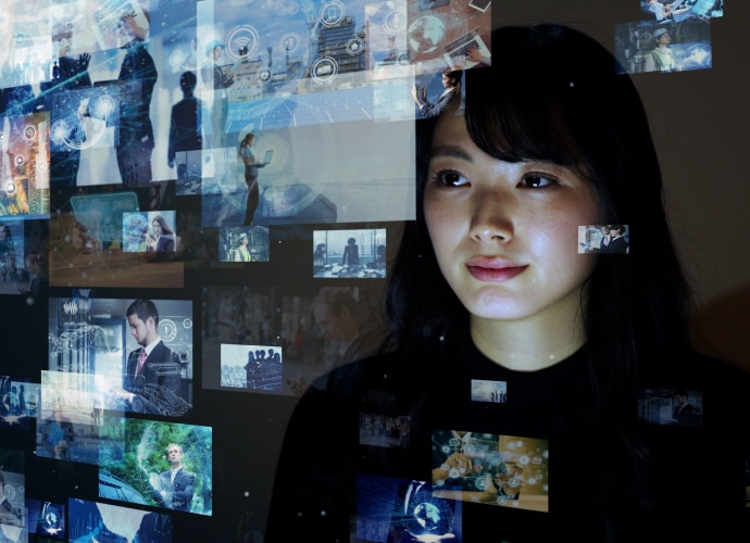 A girl is looking at a screen with multiple digital screens