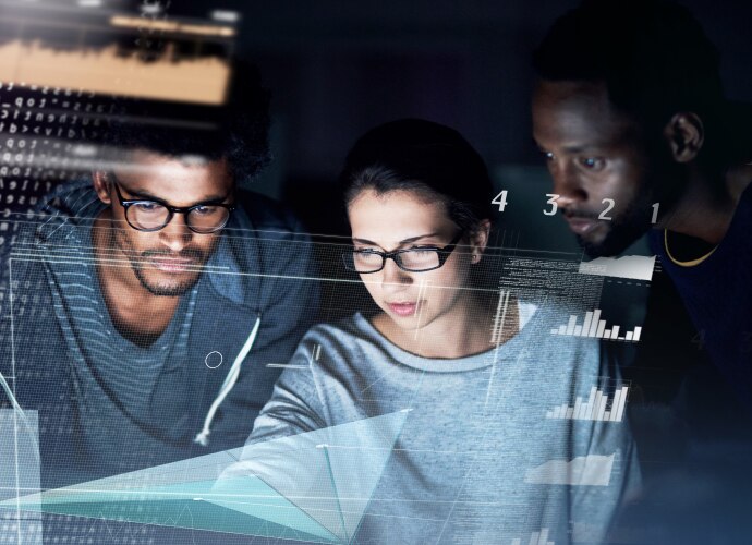 Two men and one woman checking the graphs on a PC.