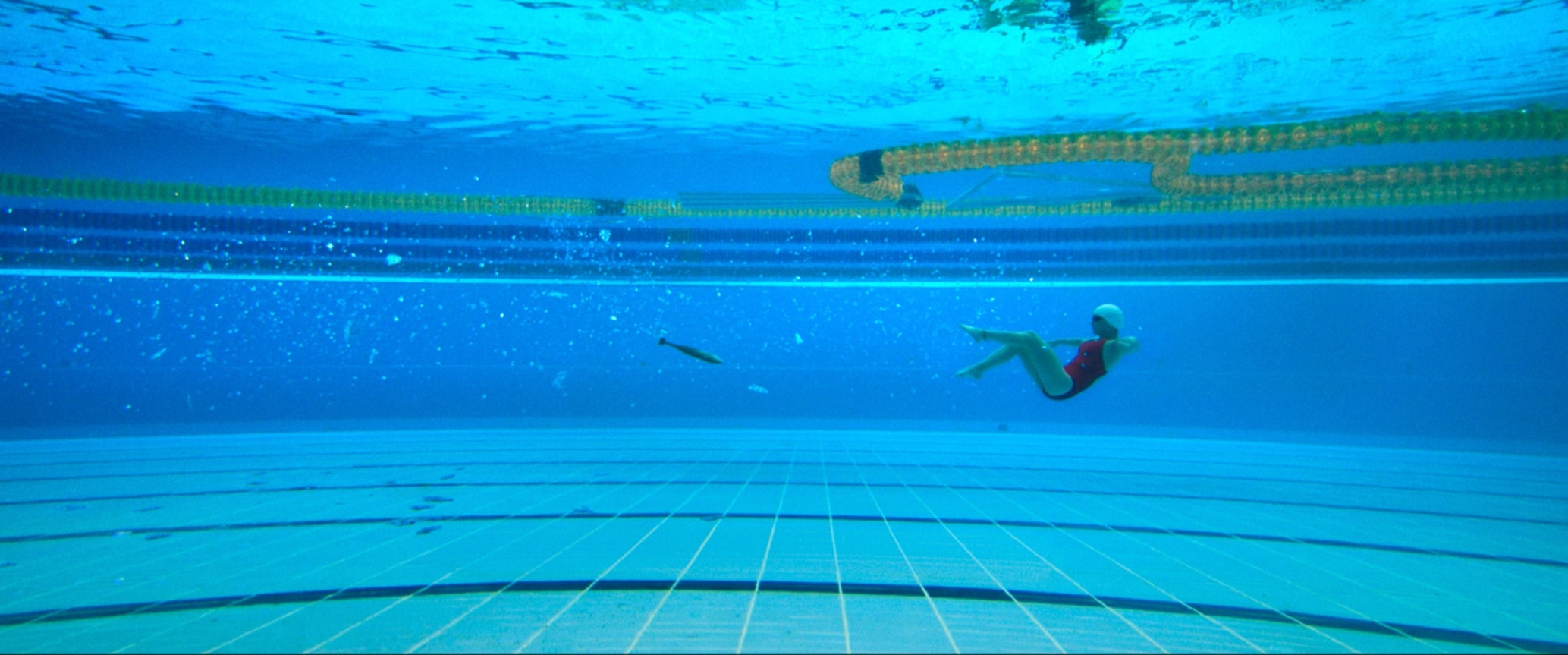 Dramatic scene from The Swimmers with bomb falling into pool