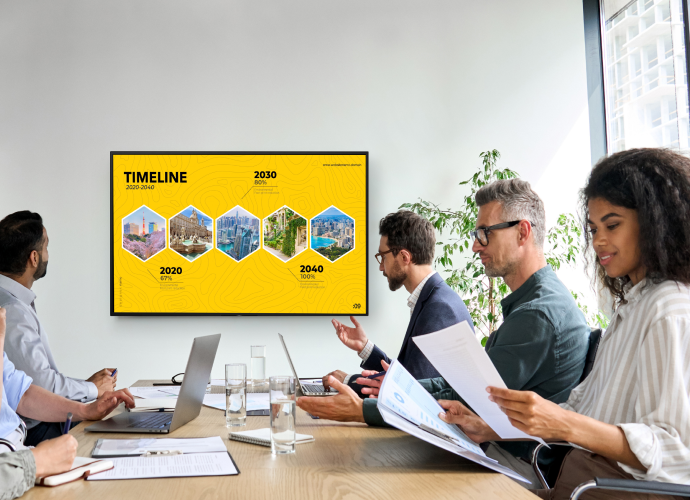 Team in meeting room with professional display mounted on the wall displaying a high contrast image