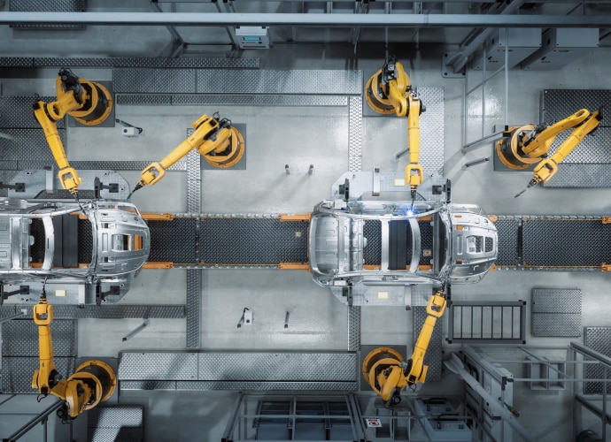 Robot machines working on a car in a factory