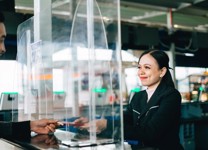 A custom officer is checking the passport of the tourist at the boarder.