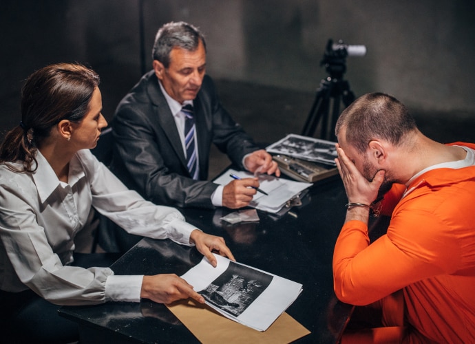 Two detectives are interrogating the criminal.