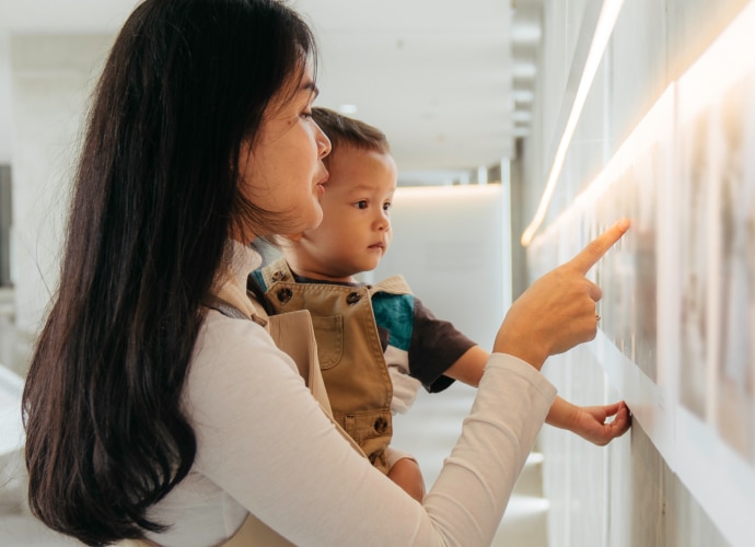 A woman holding a child and pointing.