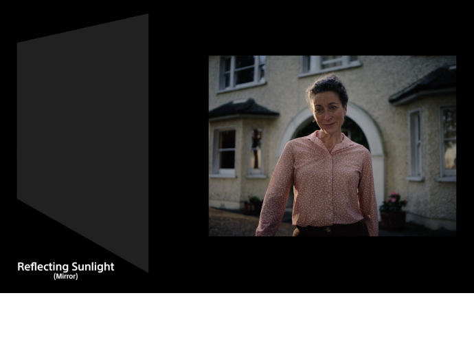 Woman in front of house with mirrors being used to create desired lighting