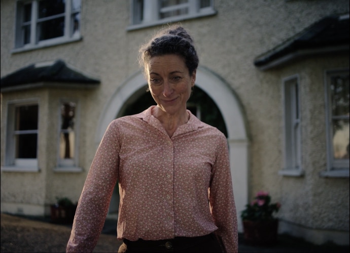 Woman outside farmhouse