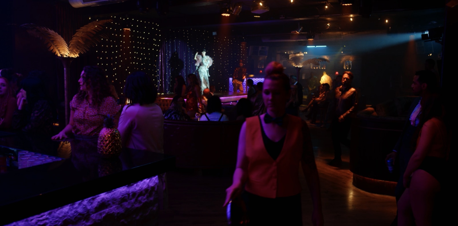 Wide shot of night club scene showing multiple practical light sources