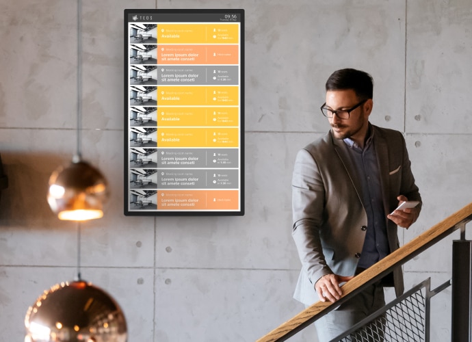 Man on stairs with screen displaying room availability