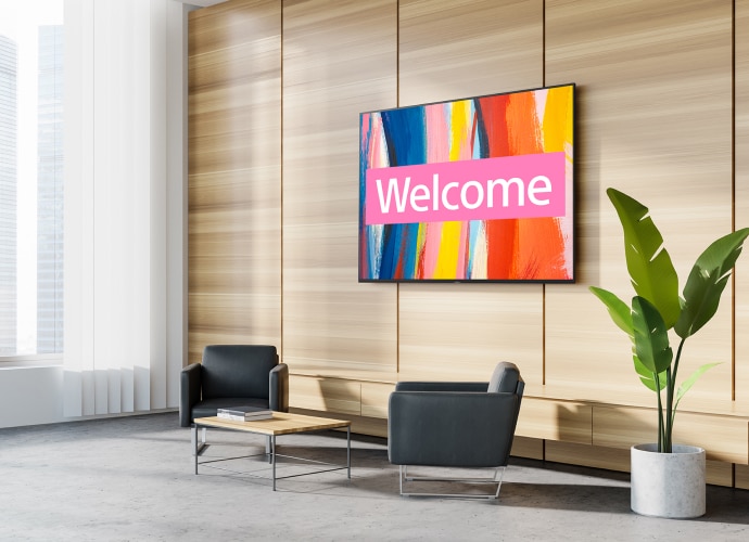 reception area with large bright screen saying “welcome”