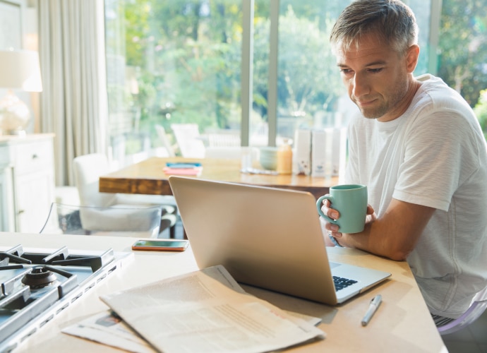 Man working on a laptop in his home kitchen