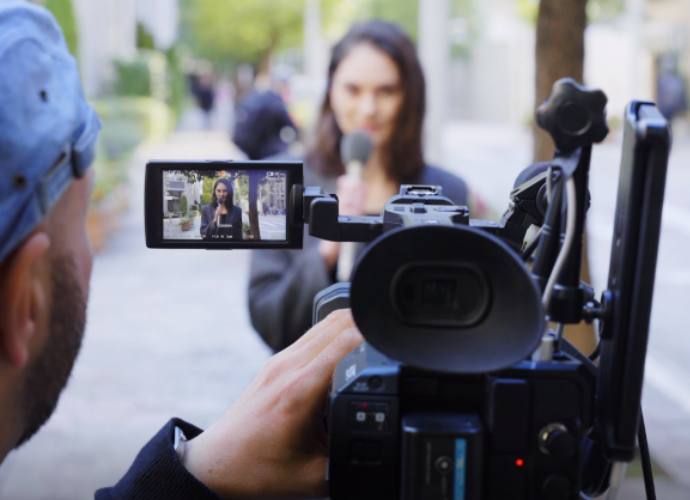 A person with a camera recording news on the street