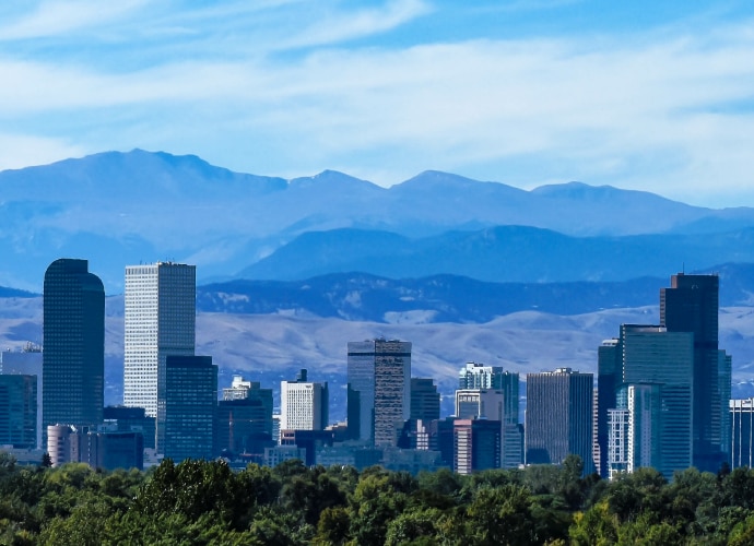 A city skyline with mountains in the background