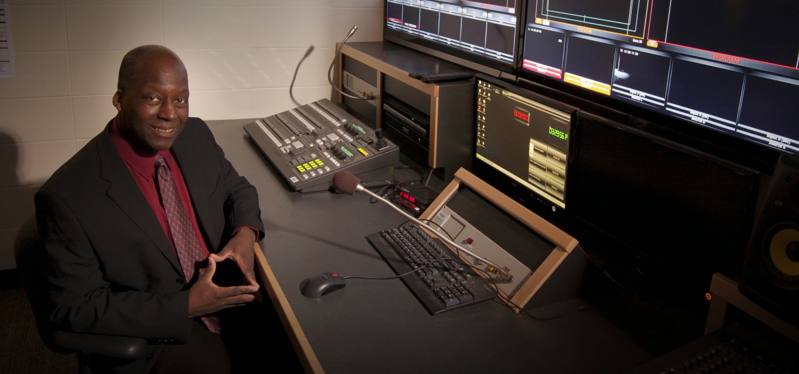 Man sitting in front of a computer controlling content on projectors