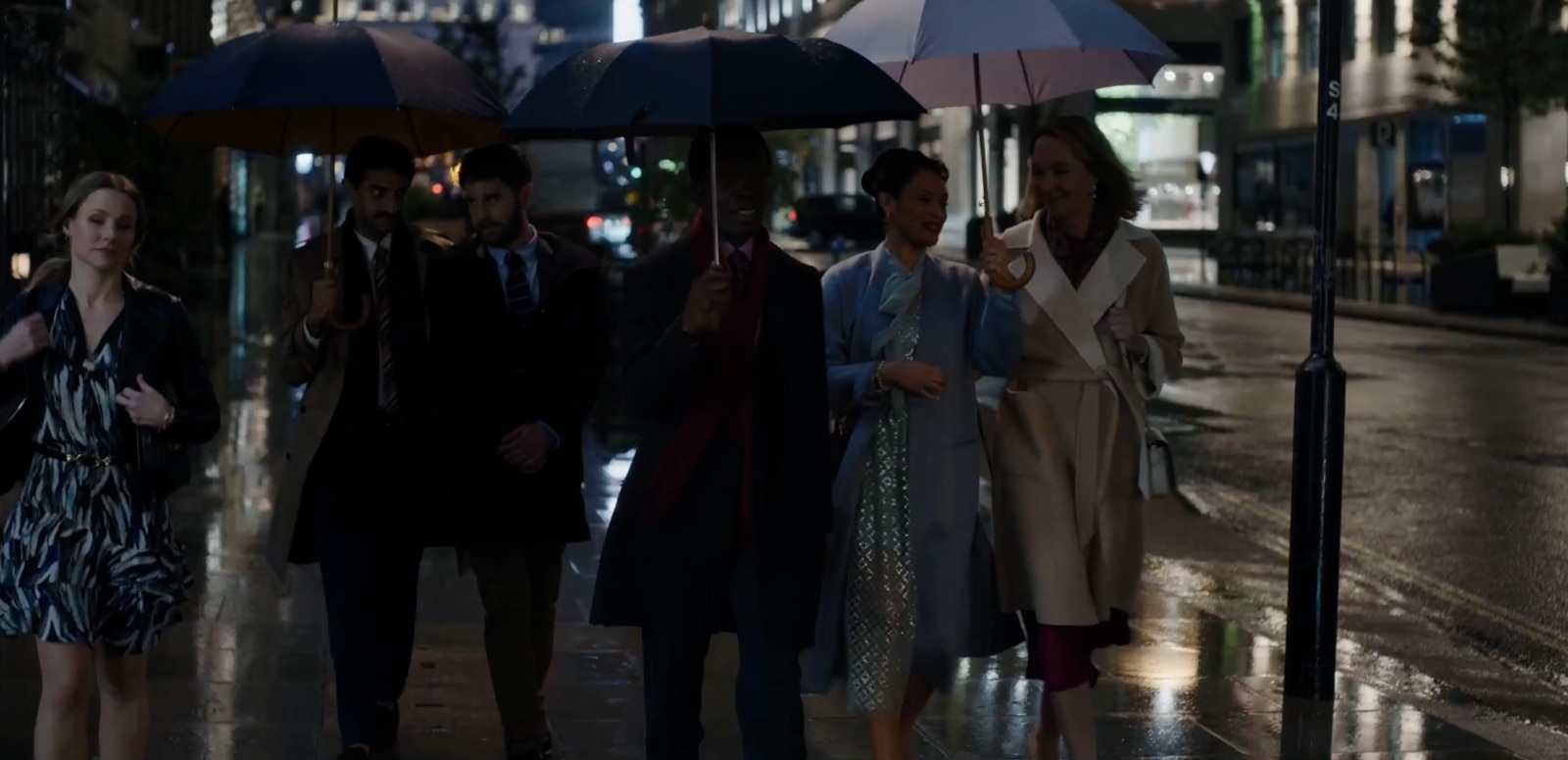 Scene from The People We Hate at the Wedding with people outside restaurant with umbrellas