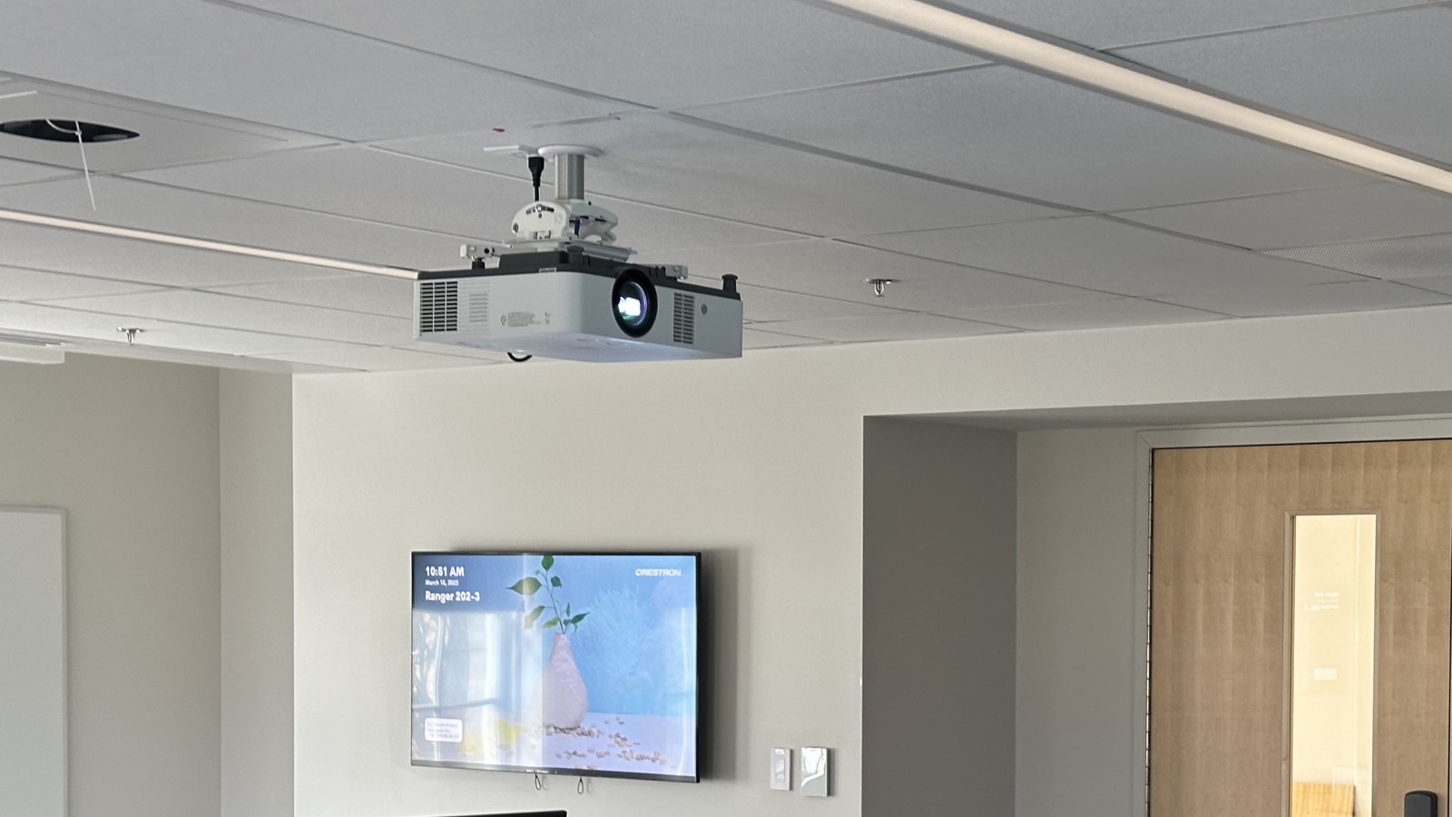 Classroom with laser projector on ceiling and bravia screen on wall.