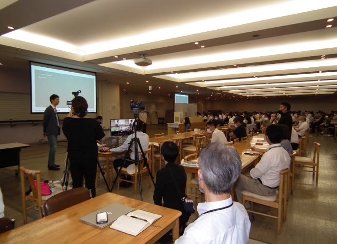 A conference room full of people looking at a large screen