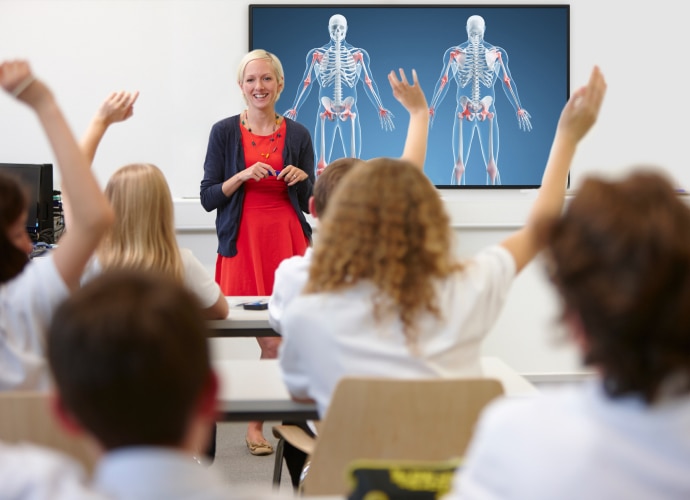 A teacher teaching a biology lesson in front of a BRAVIA display