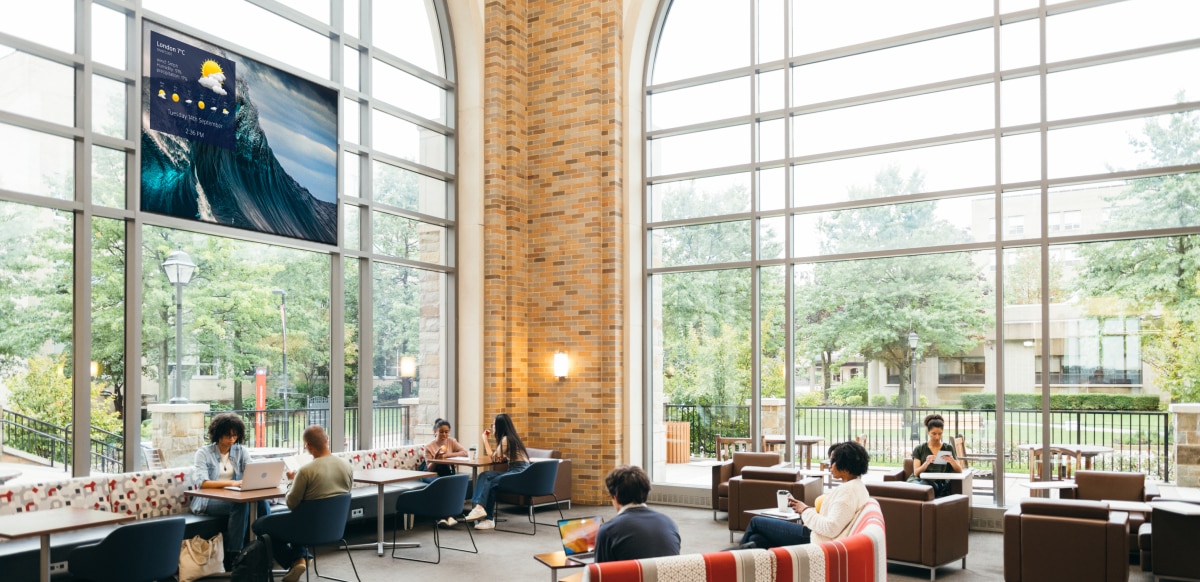 University hall with students and the BRAVIA display against the window frame