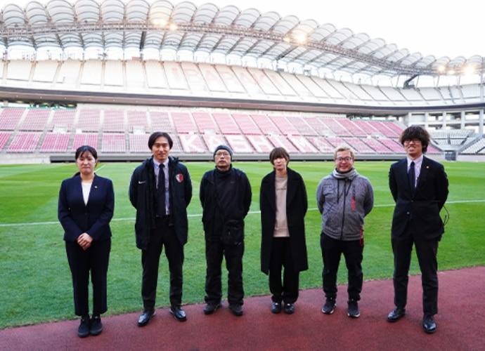 Six members of Kashima Antlers Communications Team inside the football stadium