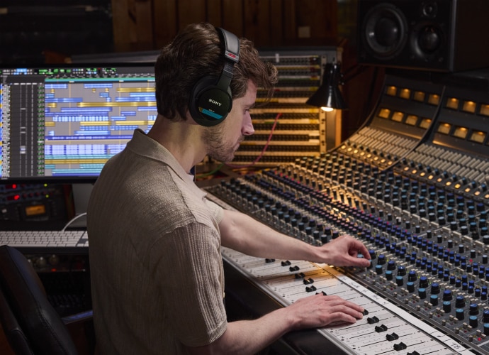 A man in a recording studio wearing Sony headphones.